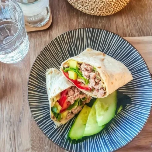 Heerlijke tonijnwrap met avocado en komkommer op een bord
