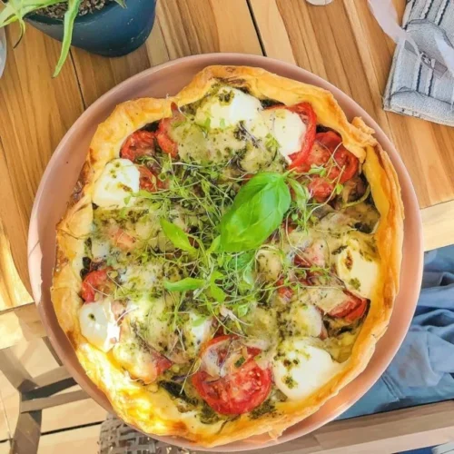 Pesto mozzarella taart met zonneblumen in een kleurrijke presentatie