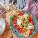 Verleidelijke meisjesdinerplank met romige burrata, verse tomaten en krokante crackers