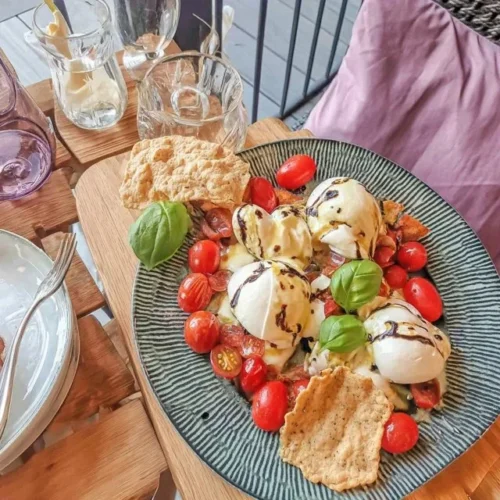 Verleidelijke meisjesdinerplank met burrata, tomaten en crackers